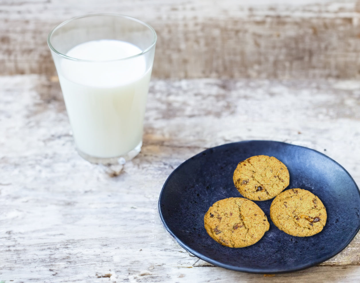 Nightfood sleep-friendly cookies, Date Night Cherry Oat flavor, on a pate with a glass of milk
